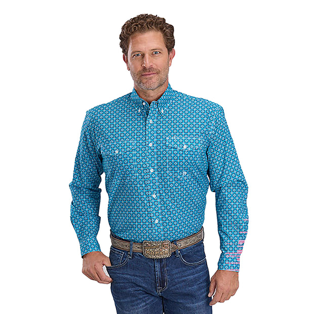 Man wearing a blue patterned shirt and jeans on a white background