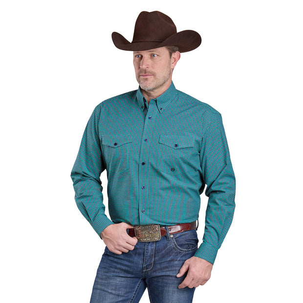Man wearing a teal patterned shirt, jeans, and a brown cowboy hat on a white background