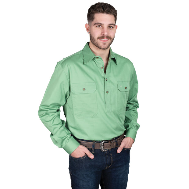 Man wearing a green shirt and dark jeans on a white background