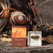 Vaquero perfume bottle and packaging on a rustic background with leather and rope.