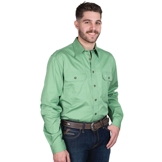 Man wearing a green shirt and blue jeans on a white background