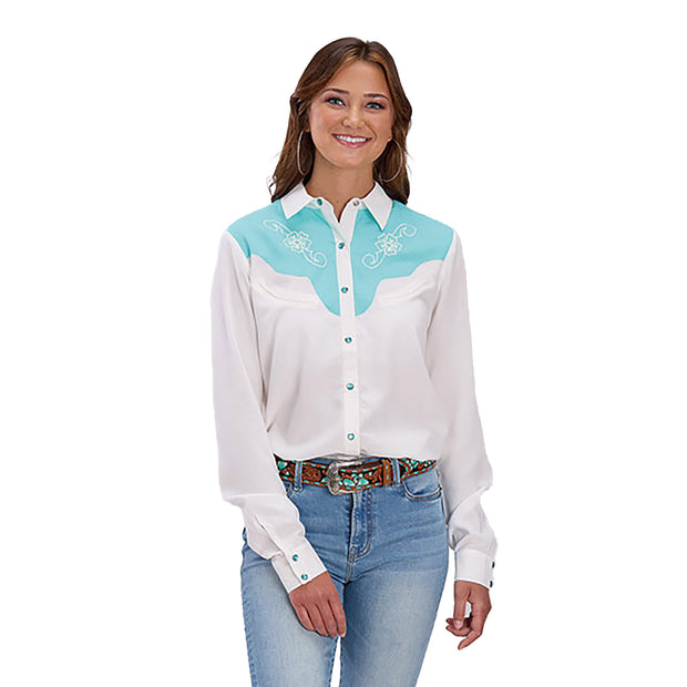 Woman wearing a white blouse with turquoise accents and jeans on a white background