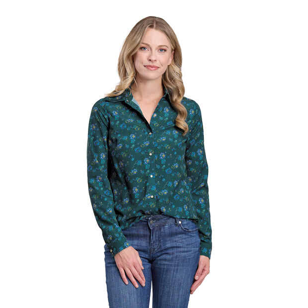 Woman wearing a green floral shirt and blue jeans on a white background
