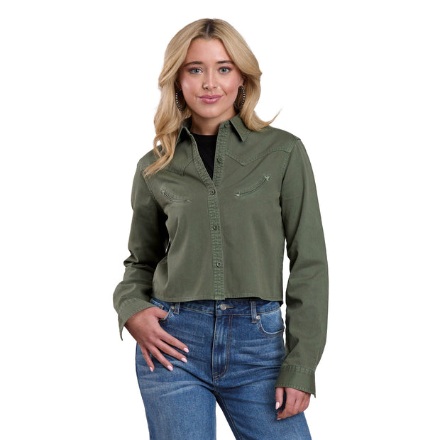 Woman wearing a green shirt and blue jeans on a white background