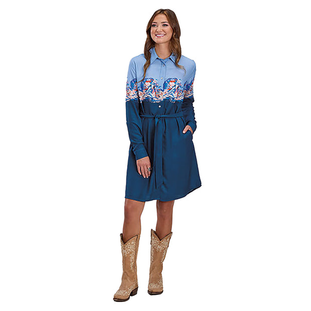 Woman wearing a blue dress with a patterned top and brown boots on a white background