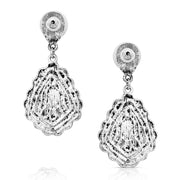 Pair of earrings with turquoise stones and intricate silver designs on a white background