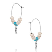 Pair of hoop earrings with bull head charms and turquoise beads on a white background