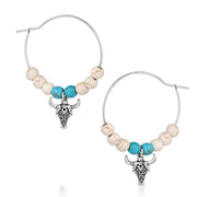Pair of hoop earrings with bull head charms and turquoise beads on a white background