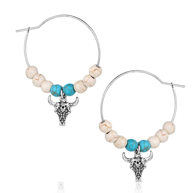 Pair of hoop earrings with bull head charms and turquoise beads on a white background