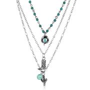 Layered necklace with turquoise beads and charms on a white background