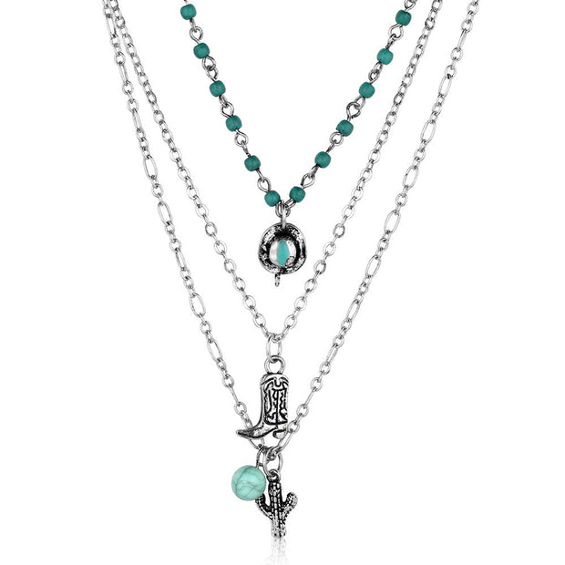 Layered necklace with turquoise beads and charms on a white background