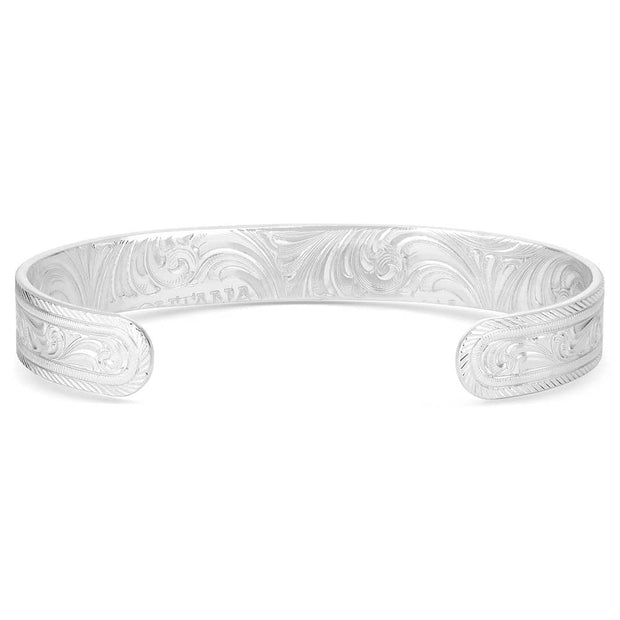 Silver bracelet with intricate designs on a white background