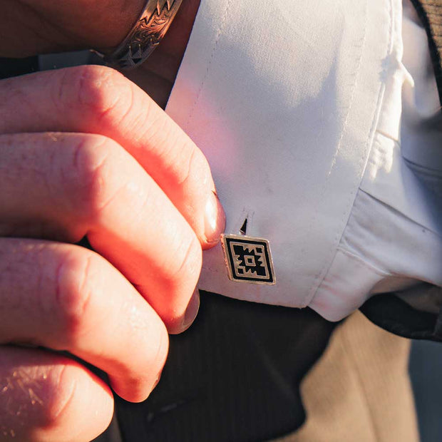 Pair of cufflinks with geometric design on a white background