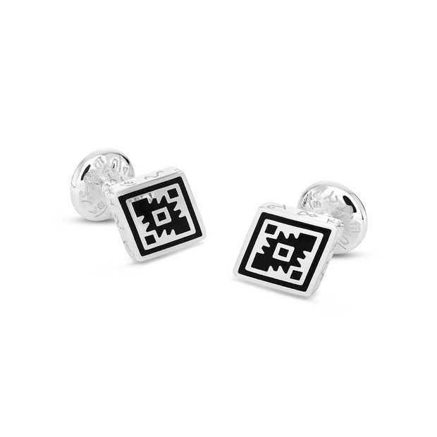 Pair of cufflinks with geometric design on a white background