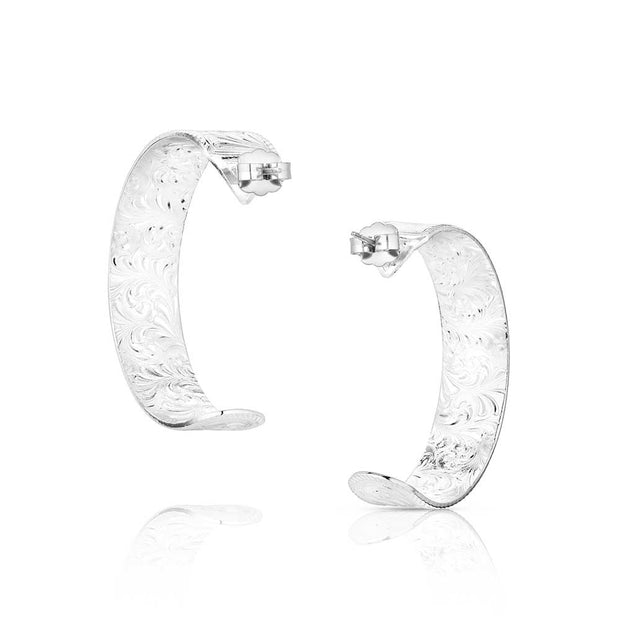 Pair of silver hoop earrings with intricate designs on a white background