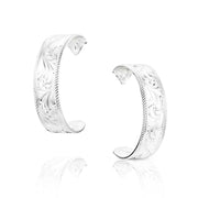 Pair of silver hoop earrings with intricate designs on a white background
