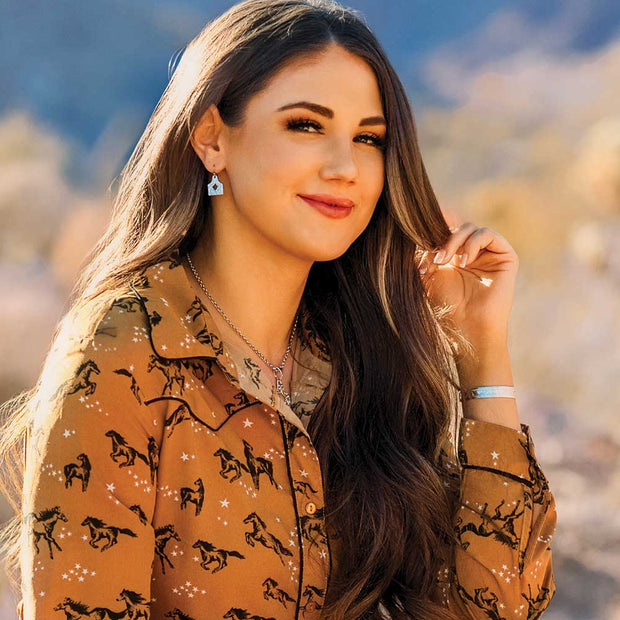 Woman wearing a patterned shirt with a blurred natural background