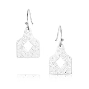 Pair of silver earrings with intricate designs on a white background