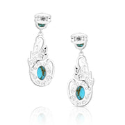 Turquoise earrings with silver wing-like designs on a white background