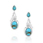 Turquoise earrings with silver wing-like designs on a white background