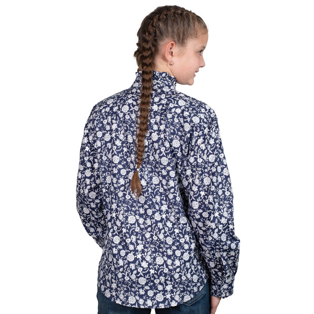 Young girl wearing a navy floral shirt on a white background