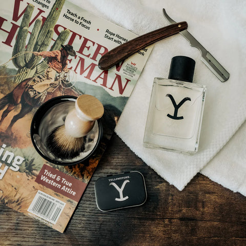 Shaving accessories including a bottle labeled 'Y', a razor, and a brush on a magazine with a Western theme.