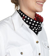 Person wearing a white shirt with a black and red polka dot scarf.