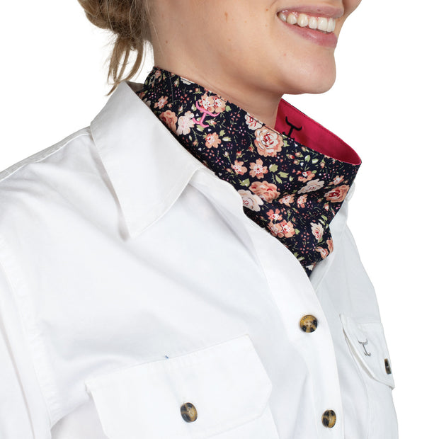 Person wearing a white shirt with a hot pink scarf and floral lining.