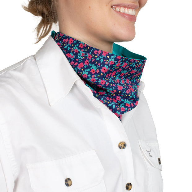 Person wearing a white shirt with a turquoise scarf and floral lining.