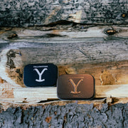Two Yellowstone branded tins on a wooden surface