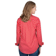 Woman wearing a red polka dot shirt with black cuffs on a white background