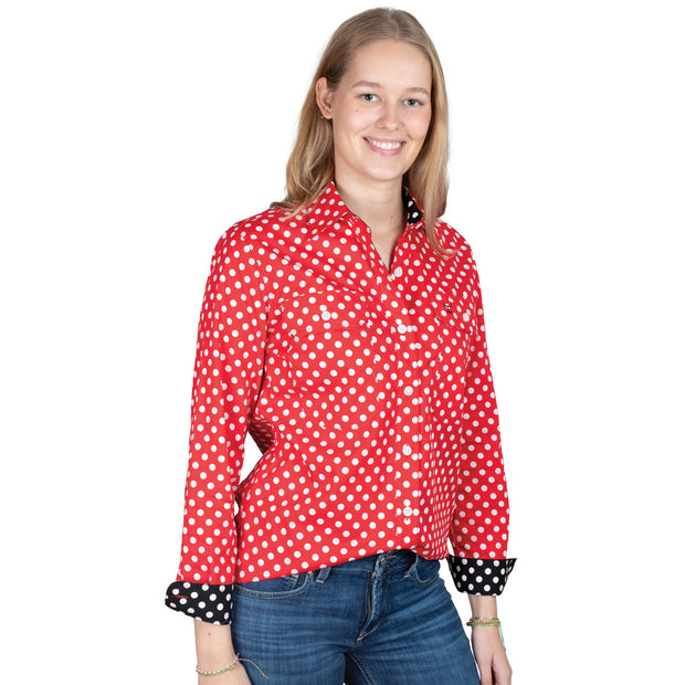 Woman wearing a red polka dot shirt with black cuffs on a white background