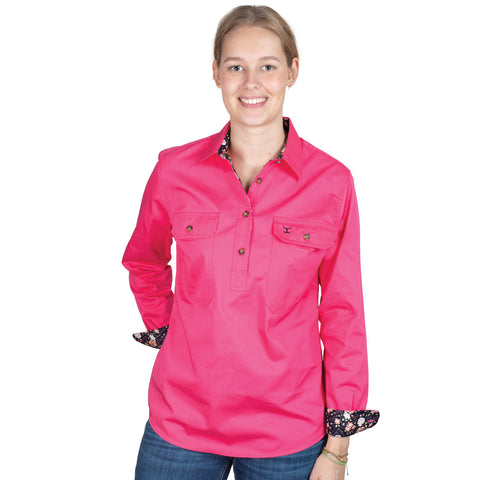 Woman wearing a bright pink shirt with floral cuffs on a white background