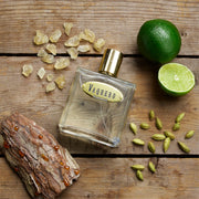 Vaquero perfume bottle with lime, cardamom, and frankincense on a wooden surface